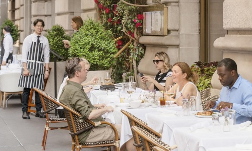 people sitting at tables outside a building