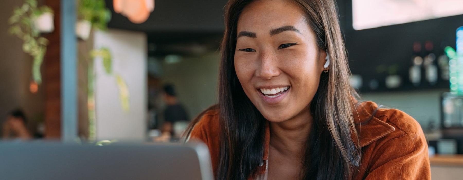 a woman smiling while working on laptop